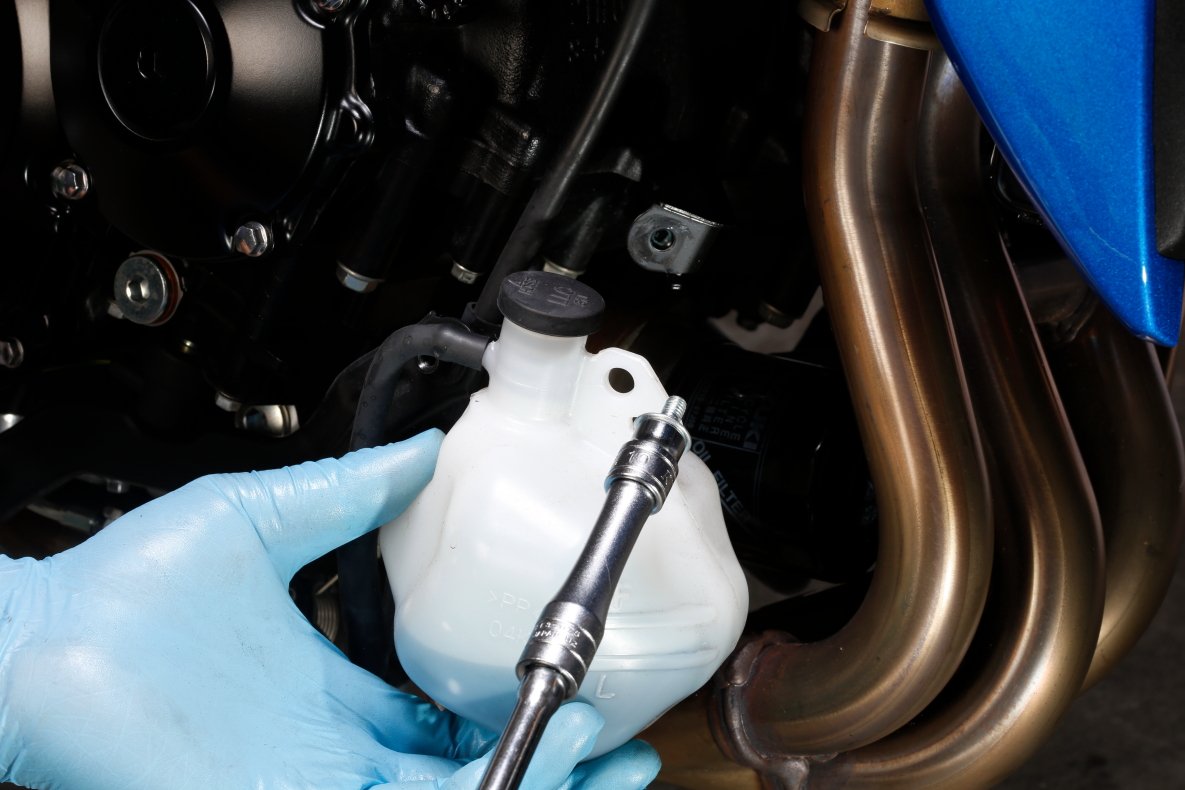 Remove the cooling water reservoir tank on the right side of the engine together with the under cowl to remove the oil filter while avoiding interference with the exhaust pipe.